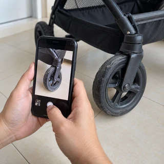 Taking a phone photo of a stroller wheel